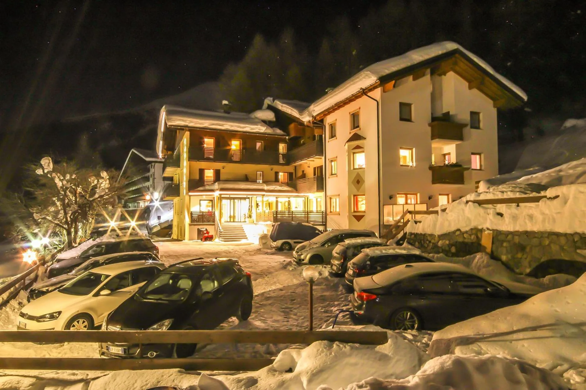 Das Hotel Cornelia an einem Winterabend, die Fenster leuchten warm