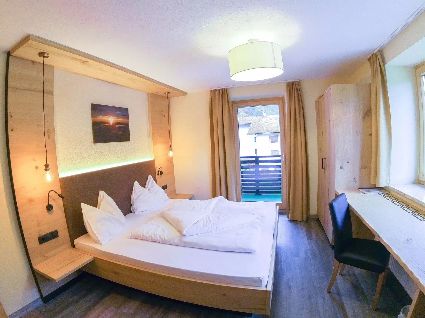 Renoviertes Doppelzimmer in hellem Altholz mit Balkontür