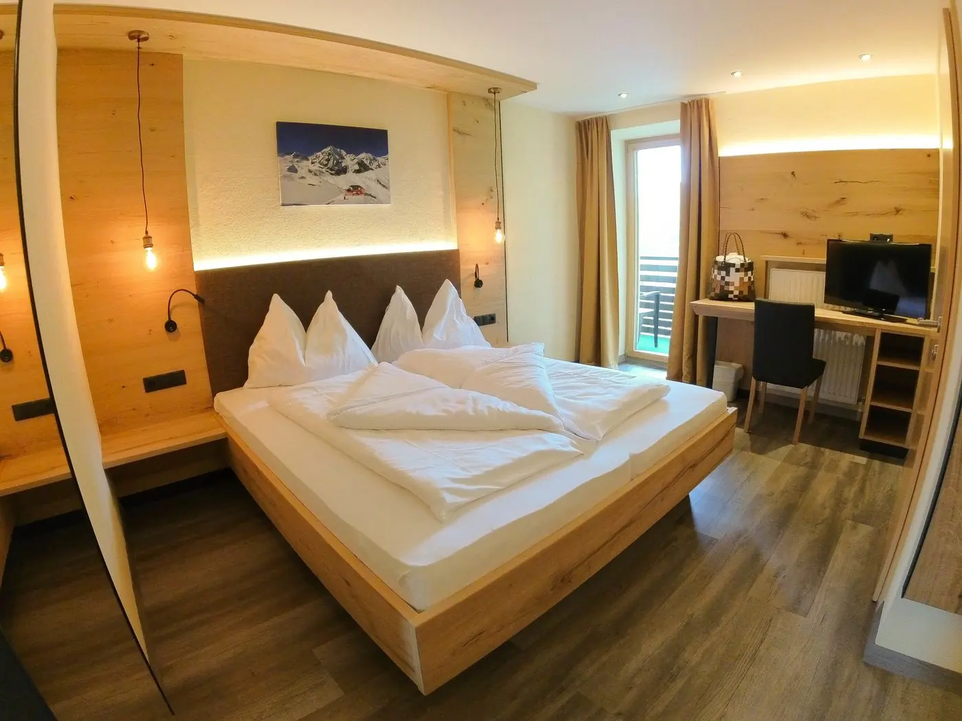 Doppelzimmer mit Holz-Kopfteil, Bergbild an der Wand und Schreibtisch