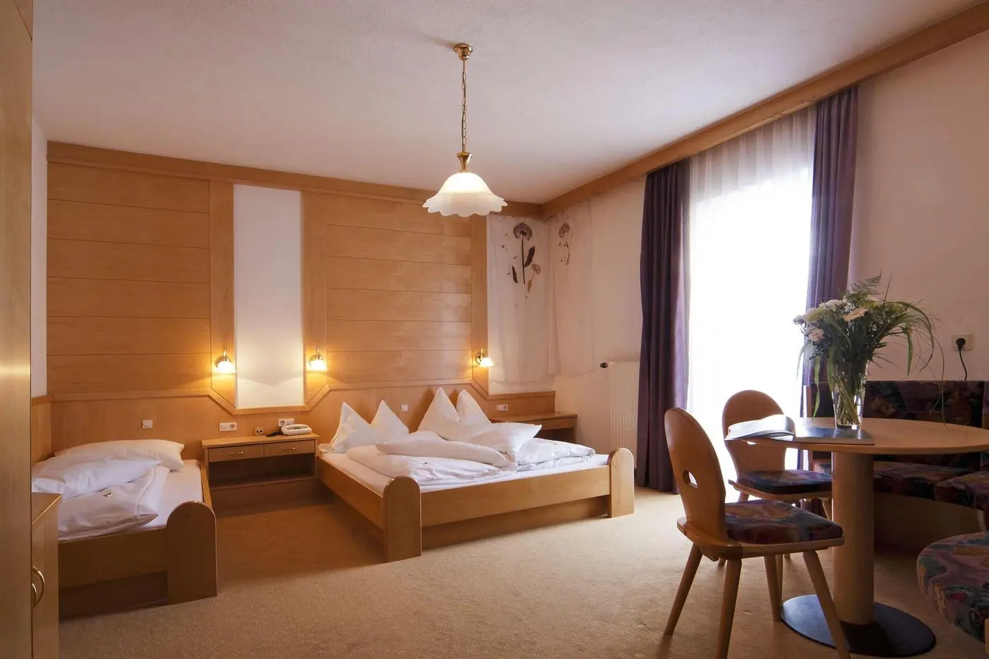 Dreibettzimmer mit Doppelbett, Einzelbett und Sitzecke